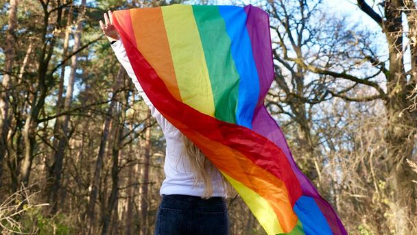 Person with LGBT flag in the forest - Photo, Image