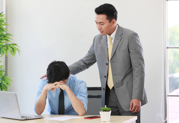 Asain üzletember megnyugtatja a fiatal alkalmazottat, aki stresszes és zaklatott a munkájától.. - Fotó, kép