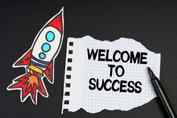Business and finance concept. On a black background, a rocket, a marker and paper with the inscription - WELCOME TO SUCCESS - Fotografie, Obrázek