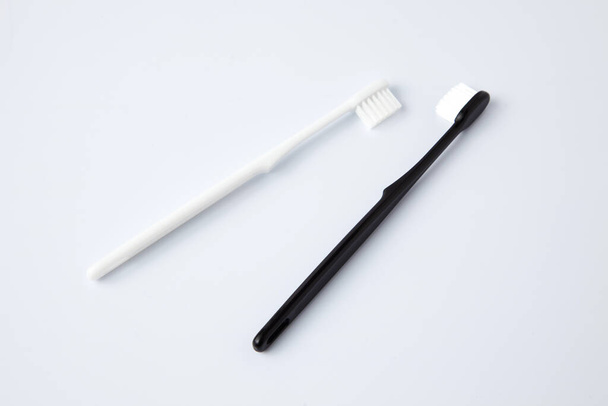 білі чорні зубні щітки туалетні приналежності ізольовані на білому тлі
 - Фото, зображення