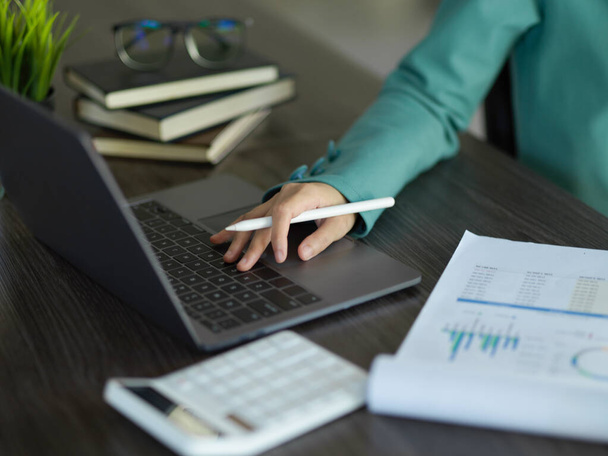 Обрезанный образ успешной предпринимательницы, работающей на ноутбуке, анализирующей финансовые данные. - Фото, изображение