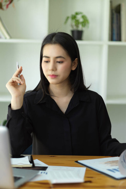 Portrait of Attractive businesswoman pensive thinking about her business at her office desk. - Photo, image