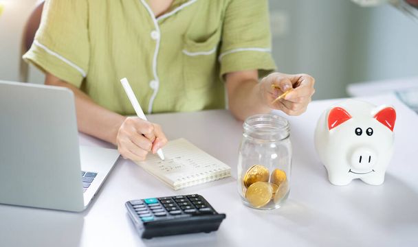 Mujer asiática calculando sus ahorros - Foto, imagen