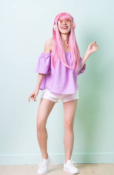 Młoda Azjatka z różowymi włosami na zielonym tle - Zdjęcie, obraz