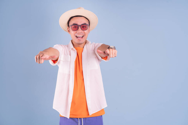 Portrait of young Asian man wearing summer clothing on blue background - Foto, Imagem