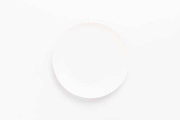 Empty ceramic round plate isolated on white background - Фото, изображение