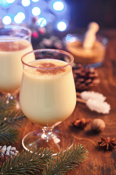 Eggnog Christmas. Delicious winter cocktail milk, rum and cinnamon served in two glasses with shortbread star shape sugar cookies, fir branch over white wooden plank table. Close up. Mock up. - Zdjęcie, obraz