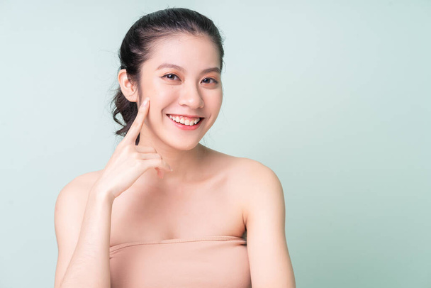 新鮮な肌を持つ美しい若いアジアの女性。顔のケア、顔の治療、緑の背景に隔離された女性の美しさの肌。美容・美容・化粧品 - 写真・画像