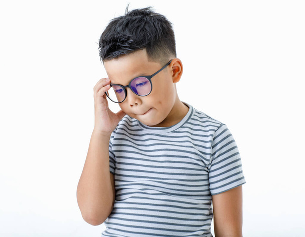 Recorte retrato de lástima joven asiático sano niño con gafas y casual camisa de rayas horizontales pensando y considerando seriamente en la dificultad y difícil de decidir la solución correcta o selección - Foto, Imagen