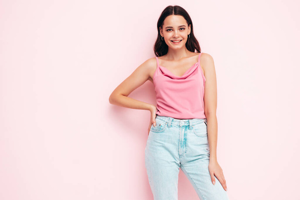 Young beautiful smiling female in trendy summer clothes. Sexy carefree woman posing near pink wall in studio. Positive brunette model having fun and going crazy. Cheerful and happy  - Фото, зображення