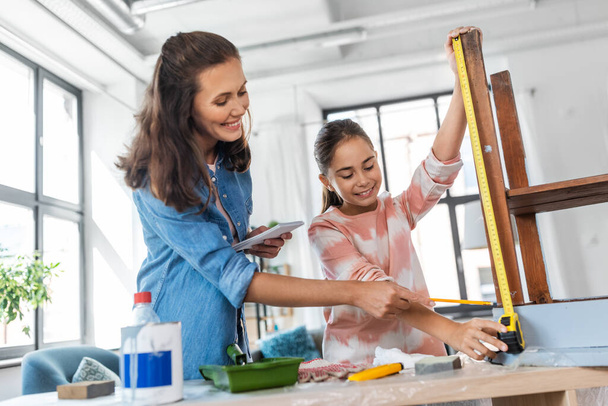 mother and daughter with ruler measuring old table - Foto, immagini