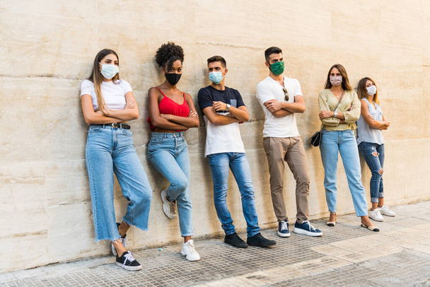 Друзья носят защитную маску для лица, чтобы избежать распространения коронного вируса - Портрет молодых людей тысячелетия во время вспышки коронавируса - Здравоохранение и молодежь многорасовый образ жизни - Фото, изображение