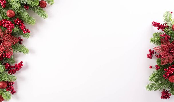 Концепція різдвяного фону. Вид зверху на гілки ялини, квітка та ягоди на білому тлі
. - Фото, зображення