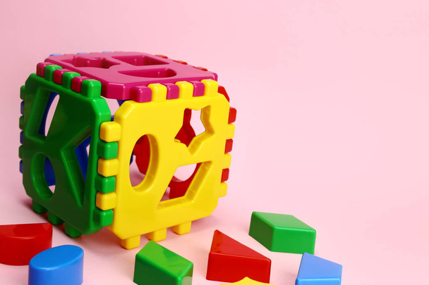 Clasificador de cubos de juego educativo para niños sobre un fondo rosa - Foto, imagen