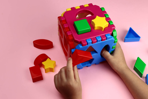Çocuk plastik parlak oyuncaklarla oynuyor, eller yakın plan. Erken öğrenim, eğitici oyunlar - Fotoğraf, Görsel