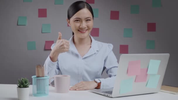 Asian woman happy confident put her fist on a left chest showing a trust at home office. - Filmagem, Vídeo