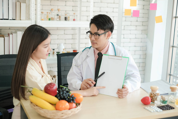 Profesional nutricionista asiático hombre consultando asia mujer en clínica o hospital o club médico - Foto, Imagen
