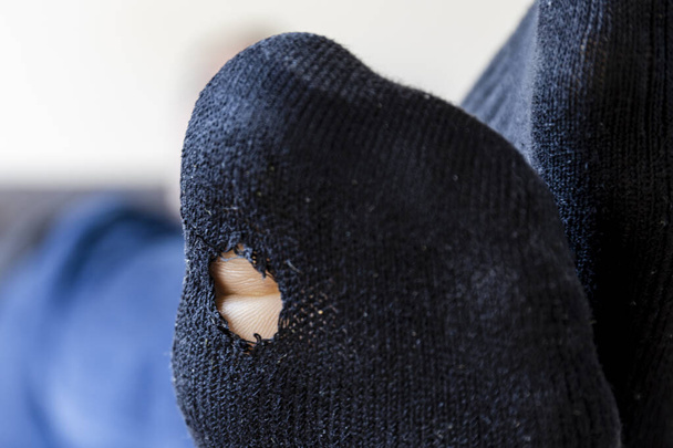 Detailní záběr černé ponožky s dírou v podrážce, ukazující špičku - Fotografie, Obrázek