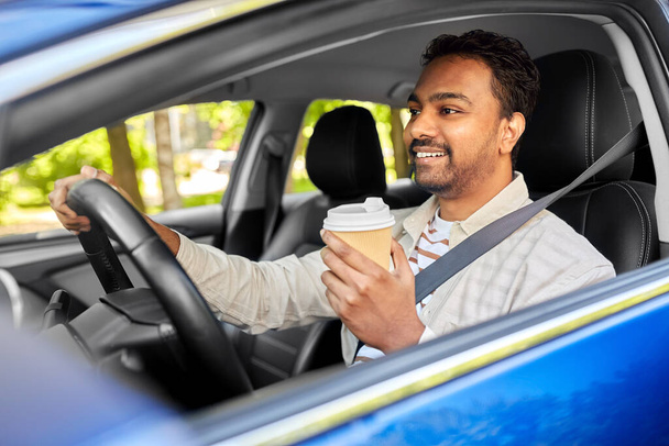 happy indian man or driver with coffee driving car - Zdjęcie, obraz