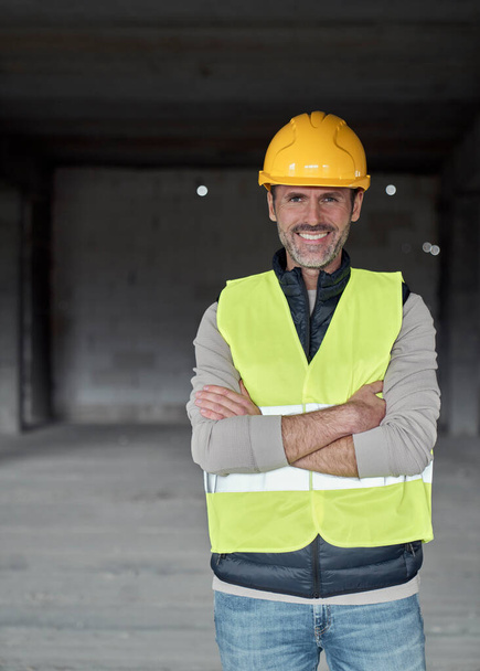 Vertical portrait of caucasian engineer standing on construction site - Photo, Image