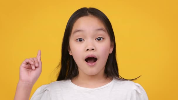 Een idee. Geïnspireerd klein aziatisch meisje met open mond wijzend vinger omhoog in inspiratie, het hebben van oplossing voor probleem - Video