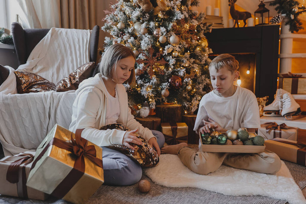 Onnellinen perhe koristelu joulukuusi boubles ja esittelee olohuoneessa, Hyvää joulua ja uutta vuotta Holidays. Perhe, talvilomat ja ihmiset käsite - Valokuva, kuva