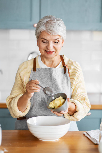 happy woman cooking food on kitchen at home - Photo, image
