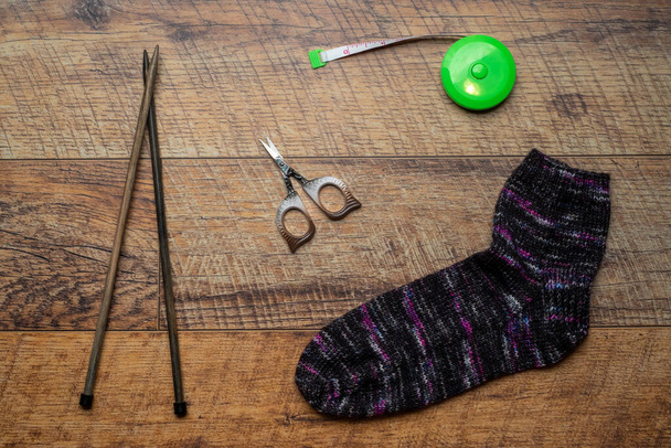 Σκούρο πολύχρωμο πλεκτό κάλτσα σε ξύλινο φόντο - Φωτογραφία, εικόνα