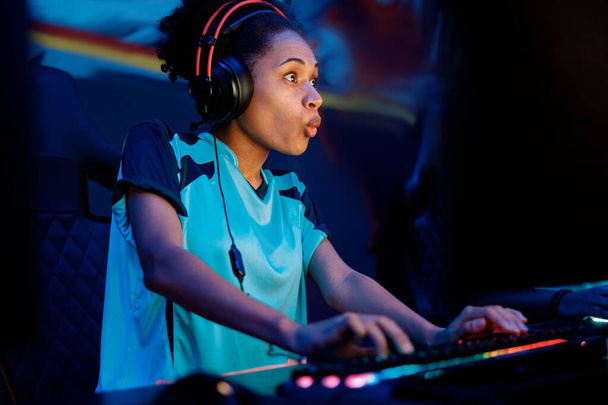 Cute African woman gaming with her friends in cyber club - Foto, Imagen