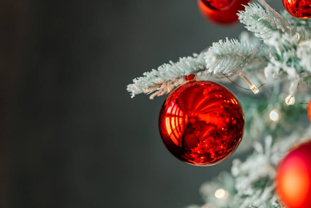 Červené vánoční hračky na větvi vánočního stromku, sníh na větvi - Fotografie, Obrázek