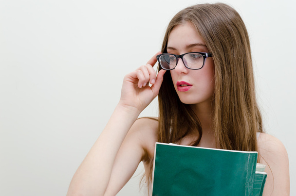 Teenage girl in glasses holding book - Fotoğraf, Görsel