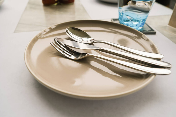 Столовая вилка и ложка на тарелке на столе - Фото, изображение