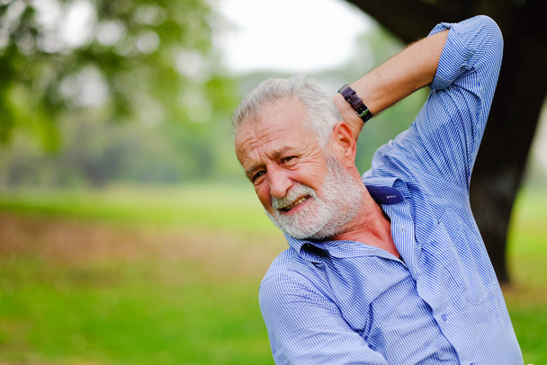 Портрет белый старик в парке, у него боли и боли после тренировки - Фото, изображение