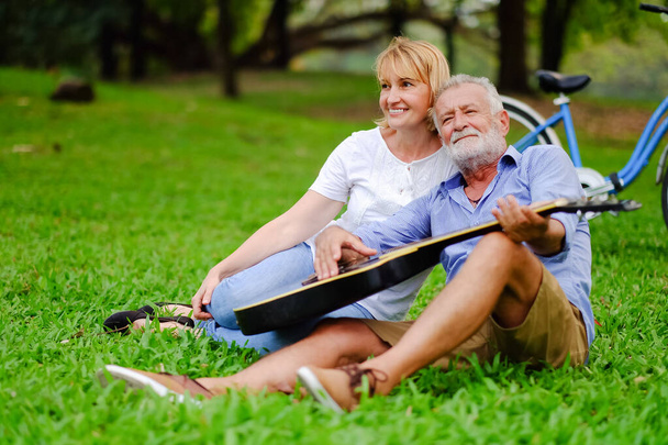 Retrato feliz dois idosos caucasianos no parque e tocar guitarra - Foto, Imagem