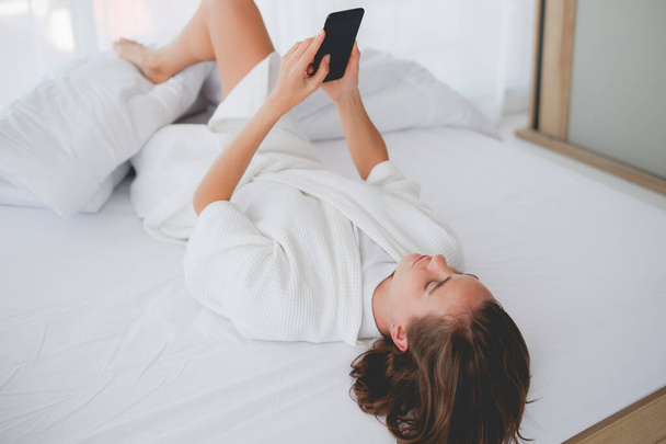 vrouw ontspannen tijd op het bed in de ochtend in rust dag - Foto, afbeelding