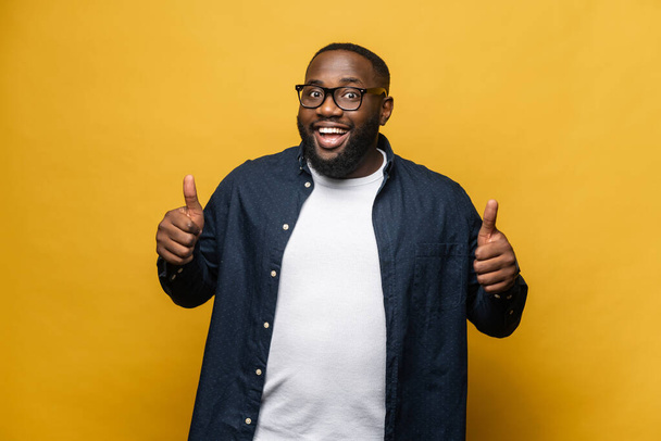 Satisfied overjoyed african-american guy showing thumb up, like sign - 写真・画像