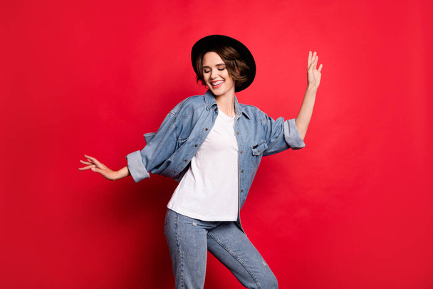 Photo portrait girl smiling wearing black hat dancing at party overjoyed isolated vivid red color background - Foto, imagen