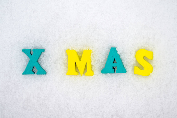 Inscripción de Navidad de letras coloridas en la superficie de nieve blanca. - Foto, Imagen