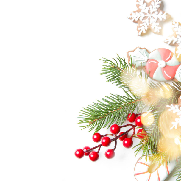 Festlich natürlich, abfallfrei, plastikfrei, Weihnachtsdekoration auf weiß mit Kopierraum. DIY Winterurlaub Wohnkultur aus traditionellen hausgemachten Keksen, Tannenzweigen, Tannenzapfen und roten Beeren. - Foto, Bild