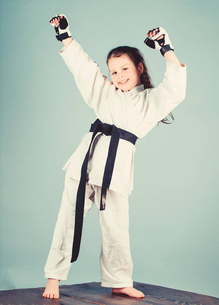 Karate fighter ready to fight. Karate sport concept. Self defence skills. Karate gives feeling of confidence. Strong and confident kid. She is dangerous. Girl little child in white kimono with belt - Φωτογραφία, εικόνα