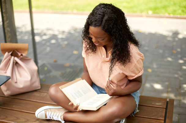 happy african student girl reading book in city - Photo, Image