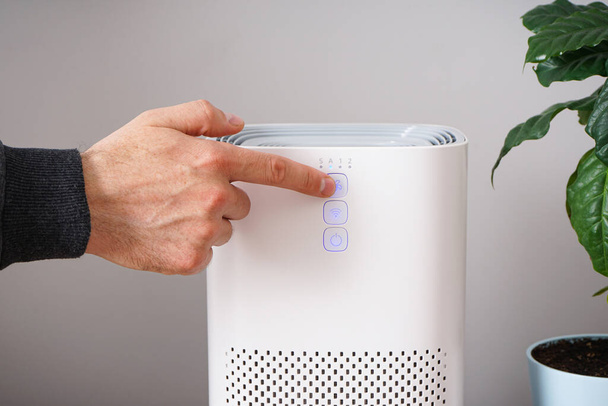 Man with modern air purifier in his room. Close-up - Photo, Image