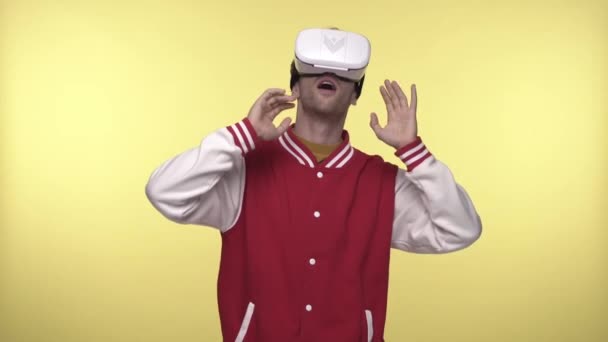 έκπληκτος άνθρωπος σε VR ακουστικά κοιτάζοντας γύρω στο κίτρινο  - Πλάνα, βίντεο