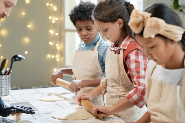 Children rolling the dough for pizza - Foto, Bild