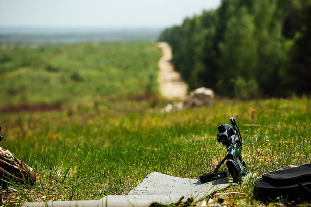 Снайперская винтовка лежит на траве на полигоне - Фото, изображение