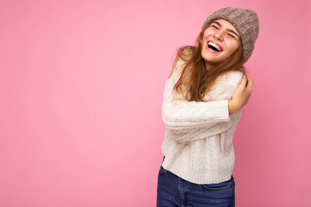 Attrayant souriant heureux jeune femme brunet debout isolé sur le mur de fond coloré portant tenue élégante quotidienne montrant les émotions faciales avoir du plaisir - Photo, image