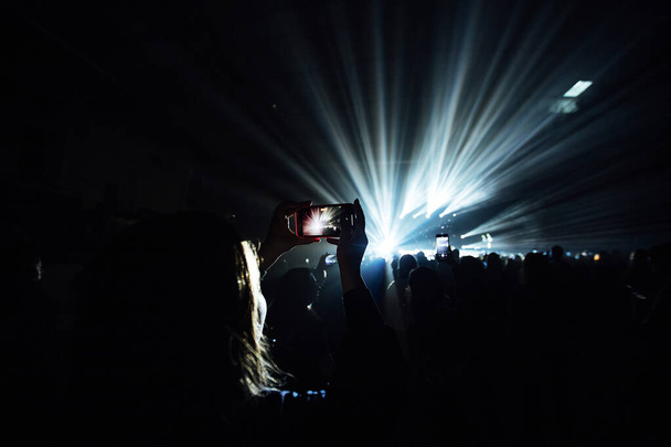 Fans filmen das Konzert mit ihrem Handy. Fotografieren Sie Ihre Lieblingsmusiker als Erinnerung - Foto, Bild