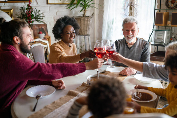 Happy multiethnic multigeneration family having fun together around kitchen table. People holiday food love happiness concept - Φωτογραφία, εικόνα