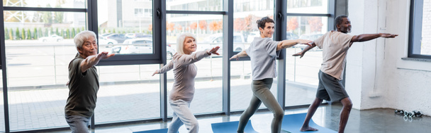 Międzyrasowe osoby starsze stojące w pozycji do jogi w centrum sportowym, sztandar  - Zdjęcie, obraz