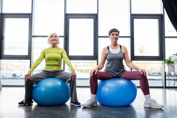 Elderly sportswomen training on fitness mats in gym  - Photo, Image